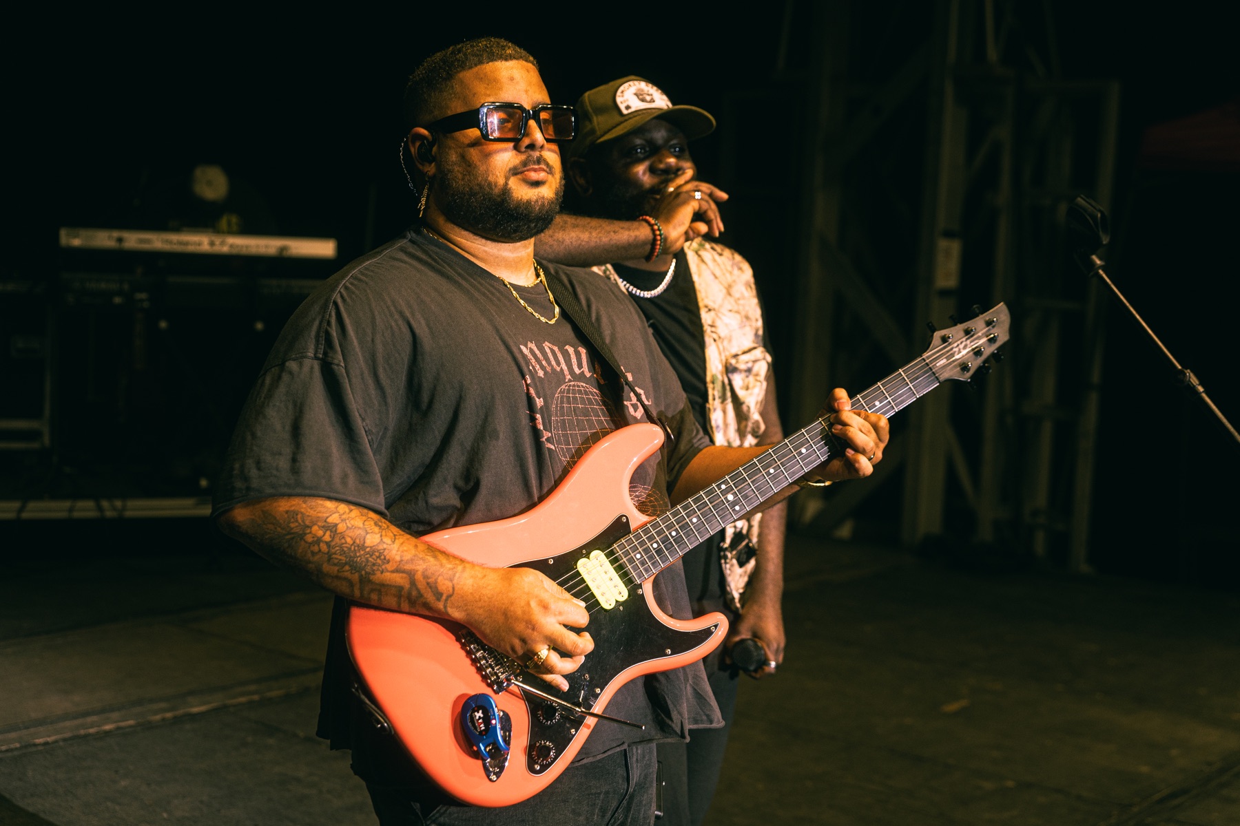 Toine holding guitar beside a vocalist on stage